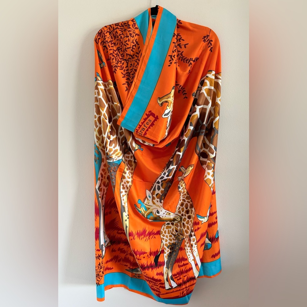 This Giraffe scarf is designed in orange, brown, and several other colors.